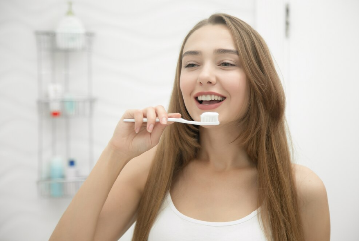 Brushing twice daily with fluoride toothpaste and daily flossing are essential routines